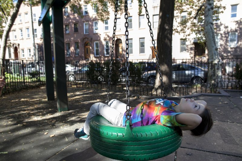 Lailah, 7, lies on a tire swing while spending time with her grandmother (who did not wish to provide a last name) at Carroll Park in the Carroll Gardens neighborhood of Brooklyn, NY on Sept. 18, 2013. Lailah is a student at the nearby Hannah Senesh Community Day School. A violent fight occurred on Monday at the park, which is popular with parents and students of nearby schools.