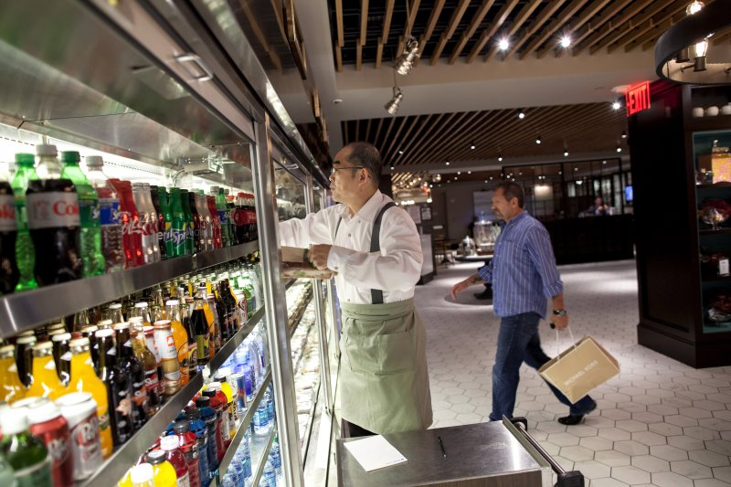 Barista Hing Wu stocks a retail section while a patron comes to shop at Herb N' Kitchen, a new dining area at the Hilton Midtown in New York, NY on Sept. 17, 2013. The restaurant, which emphasizes ready-to-go and quickly prepared made-to-order foods, opened in July. 

CREDIT: Brian Harkin for The Wall Street Journal
FIXDECODE_Hilton