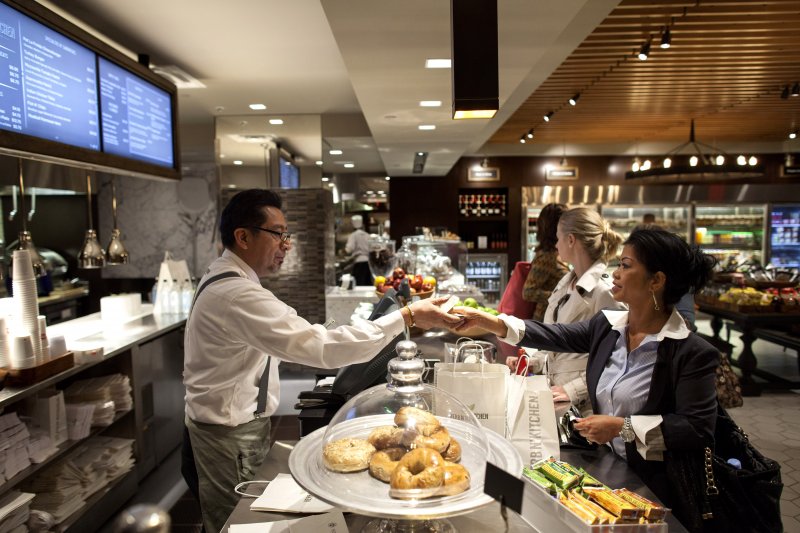 Barista Jose M. Flores, left, completes a transaction at Herb N' Kitchen, a new dining area at the Hilton Midtown in New York, NY on Sept. 17, 2013. The restaurant, which emphasizes ready-to-go and quickly prepared made-to-order foods, opened in July. 

CREDIT: Brian Harkin for The Wall Street Journal
FIXDECODE_Hilton