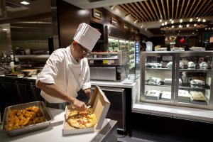 Cook Suresh Deshbhandari packages a flatbread pizza at Herb N' Kitchen, a new dining area at the Hilton Midtown in New York, NY on Sept. 17, 2013. The restaurant, which emphasizes ready-to-go and quickly prepared made-to-order foods, opened in July. 

CREDIT: Brian Harkin for The Wall Street Journal
FIXDECODE_Hilton